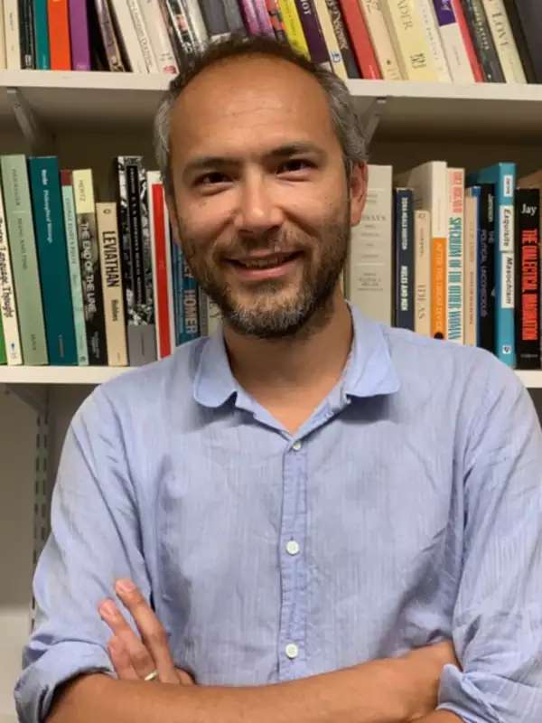 an image of Andrew Lynn in front of a bookcase