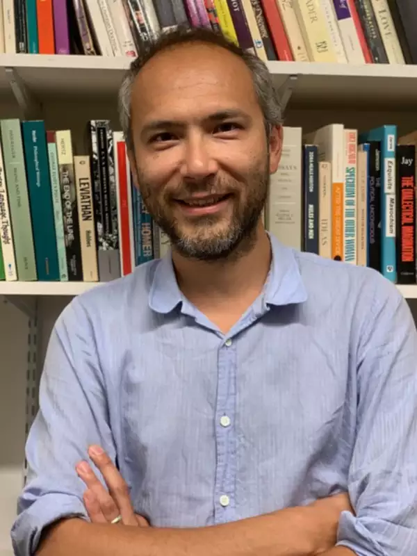 an image of Andrew Lynn in front of a bookcase