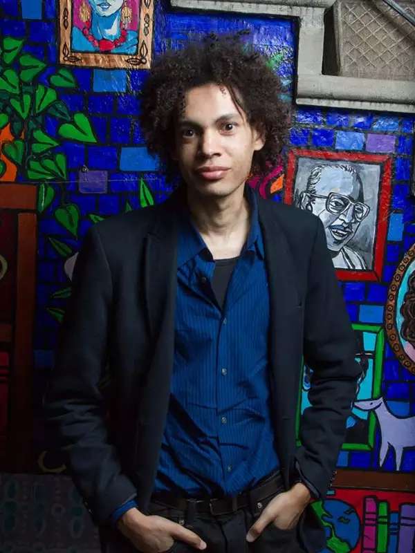 a Black man with natural hair looking directly at the camera